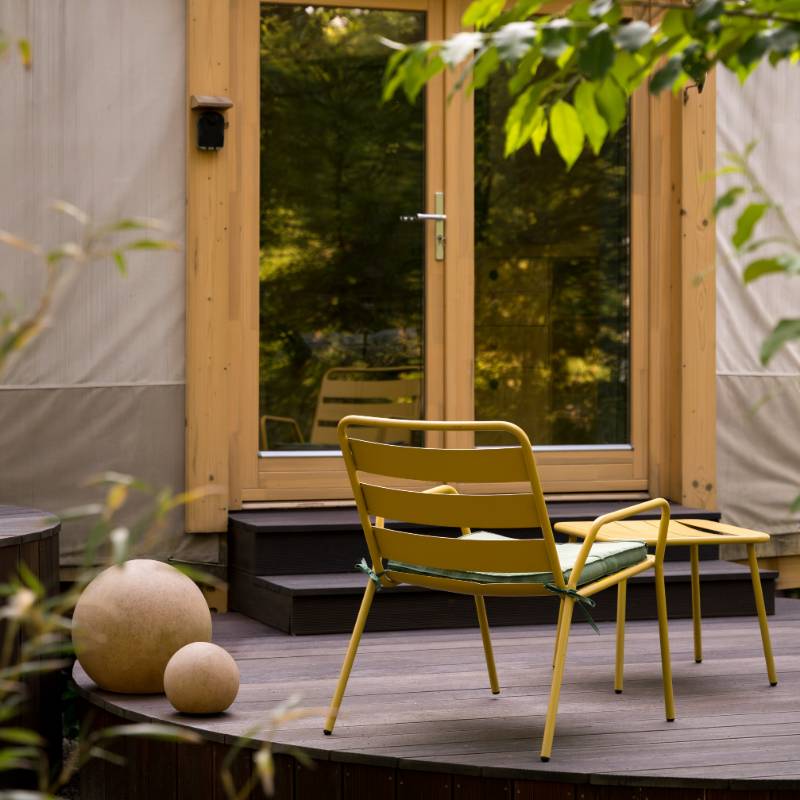Terrasse avec fauteuil jaune et décorations - réserver un hébergement insolite