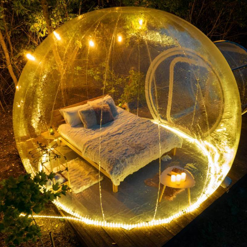 lit confortable dans une bulle transparente éclairée la nuit